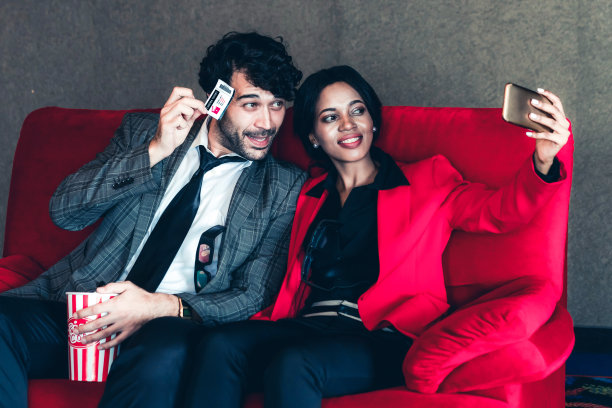 一对男女拿着一张票拍照图片下载