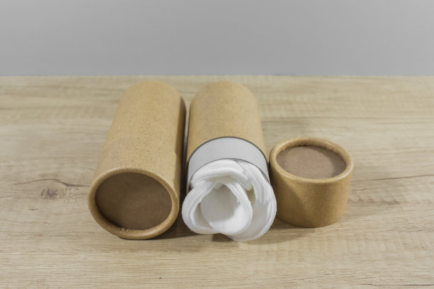 木桌上放着纸管，里面有白色的棉花圆盘。回收的概念显示如何重复使用塑料免费纸板包装管天然化妆品在家里。顶部视图与复制空间图片下载
