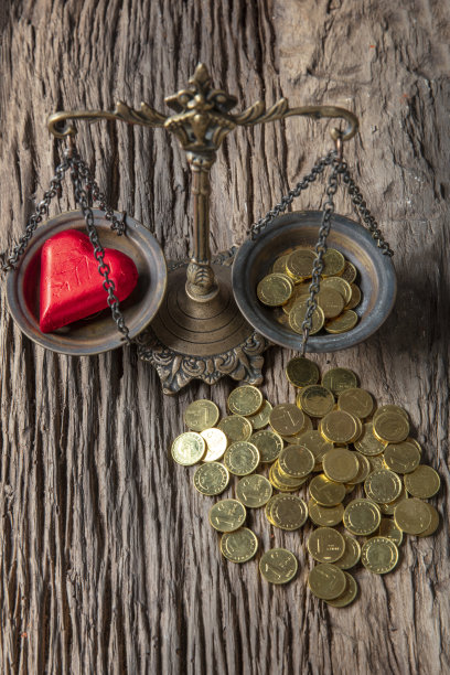 老式的天平显示爱情比金钱更有优势。情人节的概念。图片下载