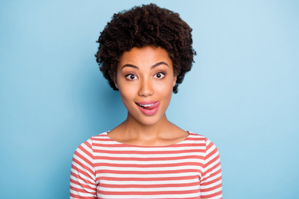 特写照片惊人的黑皮肤女士风骚的心情舔上嘴唇粘舌头出嘴穿条纹白红色衬衫孤立的蓝色柔和的颜色背景图片下载