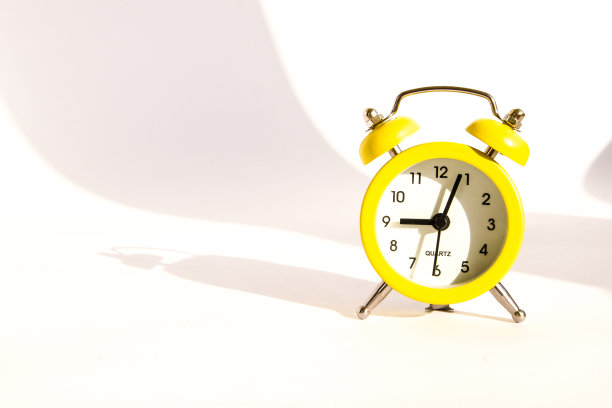 黄色闹钟与大阴影的白色背景，复制空间图片下载