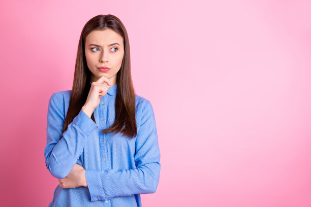 这张照片是一位年轻的首席执行官正在规划她的公司的发展，她穿着蓝色的衬衫，背景是粉红色的图片下载