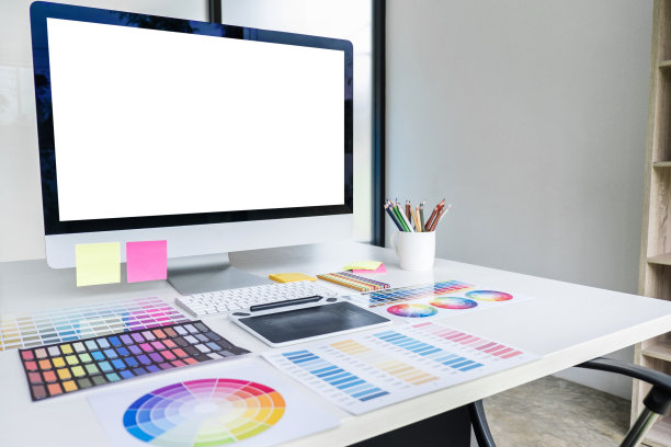 白色桌子上的台式电脑屏幕、图形设计师和色板样品图片下载