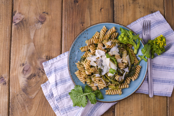 木桌上放着一盘意大利面和帕尔马干酪。意大利南部的传统食物，来自普利亚。乡村风格的照片。图片下载