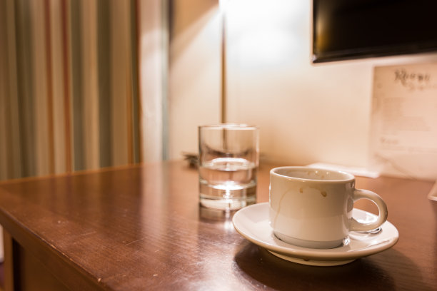 酒店房间的水和咖啡放在一张木桌上。图片下载
