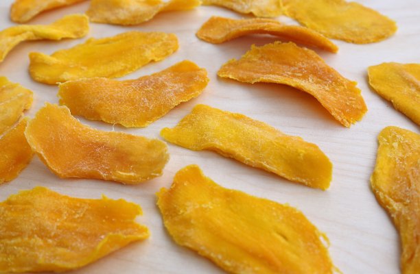 芒果被切成长条，在阳光下晒干，黄色的躺在木板上，准备当早餐吃图片下载