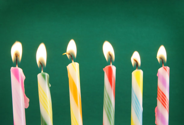 绿色背景上的彩色生日蜡烛图片下载