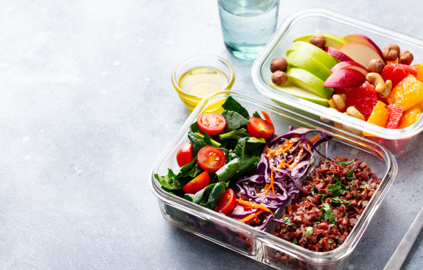 午餐盒有蔬菜，糙米和水果沙拉。健康饮食。灰色背景。副本的空间。图片下载