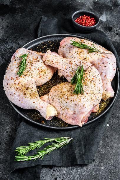 生鸡腿与大腿，新鲜香草，烹饪。黑色背景。俯视图图片下载