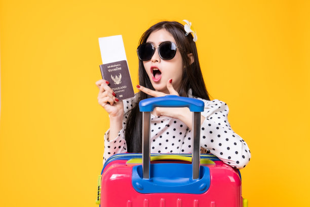 夏日休闲装的女游客。亚洲微笑女子。以黄色为背景出国旅行的乘客。一个亚洲女人要去度暑假。旅行有趣的旅行。图片下载