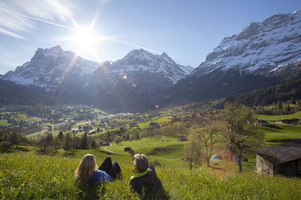 一对成熟的夫妇在山上的草地上放松，看向别处图片下载