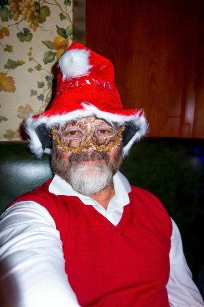 活跃的老人有乐趣在夜店面具和圣诞老人帽子图片下载