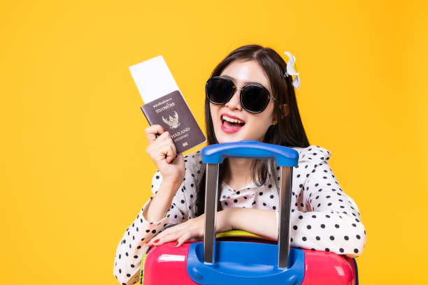 夏日休闲装的女游客。亚洲微笑女子。以黄色为背景出国旅行的乘客。一个亚洲女人要去度暑假。旅行有趣的旅行。图片下载