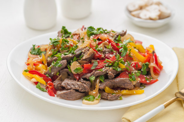 肉和蔬菜。一大盘菜装在白色的盘子里。可以吃了。图片下载