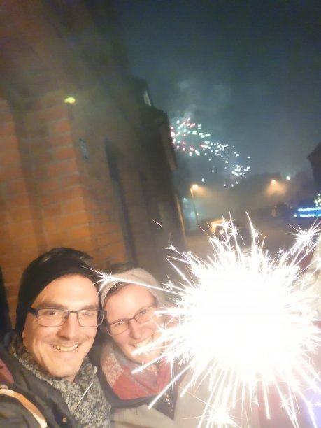 年轻夫妇的除夕庆祝与火花和烟花垂直图像图片下载