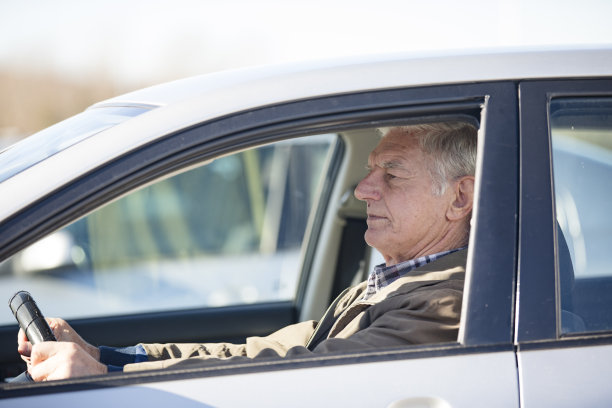 高级男子坐在汽车上的停车场-库存照片图片下载