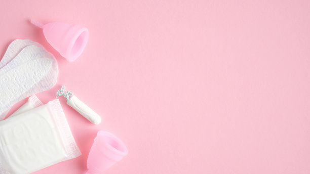 月经卫生产品。俯视图卫生巾，可重复使用的硅胶杯，粉色背景的卫生棉条与复制空间。危急日子、月经周期、女性保健理念图片下载