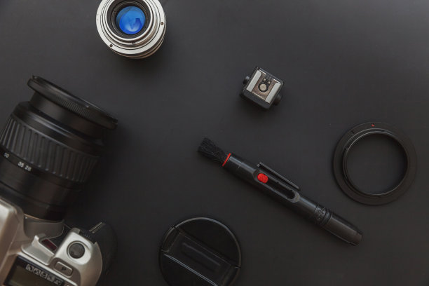 摄影师工作场所的数码单反相机系统，相机清洁套件，镜头和相机配件在暗黑色的桌子背景。爱好旅游摄影概念平铺俯视图拷贝空间图片下载