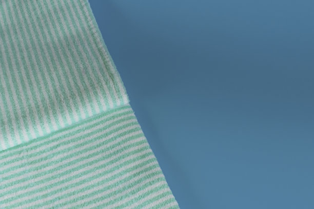 蓝色背景上柔软的毛巾布毛巾。浴巾。个人物品。图片下载