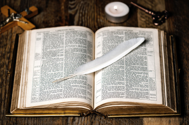 打开的旧圣经和白色羽毛图片下载