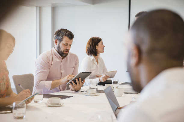 成熟的男人在商务会议中使用平板电脑图片下载