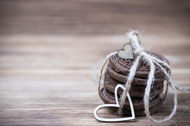 木质背景上的巧克力饼干三明治。木头和红色的心。情人节快乐。漂亮的图片与饼干。纹理。妇女节。图片下载