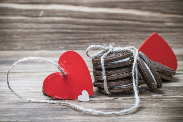 木质背景上的巧克力饼干三明治。木头和红色的心。情人节快乐。漂亮的图片与饼干。纹理。妇女节。图片下载