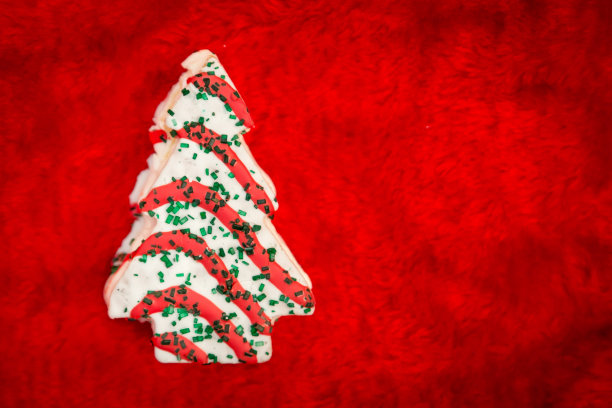 圣诞树形状的蛋糕在纯红色的背景图片下载