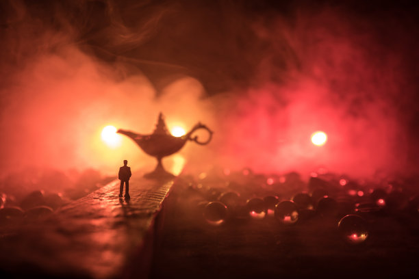 一个人的剪影站在路中央在一个雾蒙蒙的夜晚与巨大的古董阿拉丁天方夜谭精灵风格的油灯。创意艺术品装饰图片下载