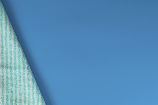 蓝色背景上柔软的毛巾布毛巾。浴巾。个人物品。图片下载