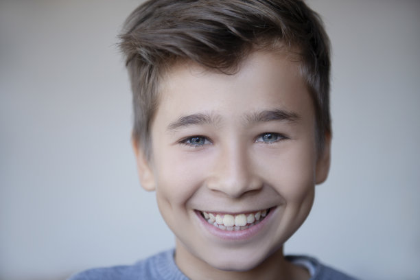 一位笑着看向镜头的十几岁男孩的特写肖像图片下载