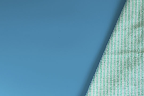 蓝色背景上柔软的毛巾布毛巾。浴巾。个人物品。图片下载