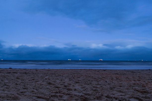 傍晚海滨的景色。海面平静，海岸荒芜，映衬着落日的天空图片下载