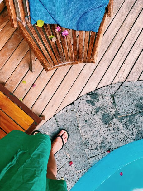 平坦的海滩生活，女孩穿着人字拖的脚，游泳池，木地板从上面拍摄图片下载