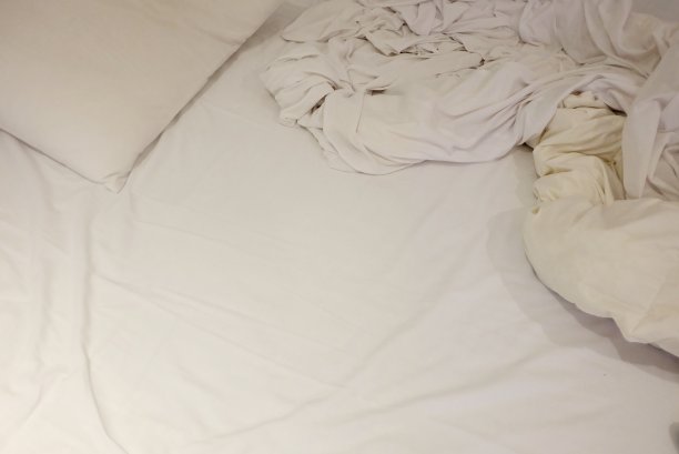 卧室里的白色皱巴巴的床单图片下载