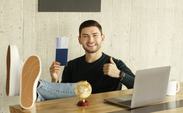 快乐的家伙拿着机票坐在办公室里竖起大拇指图片下载