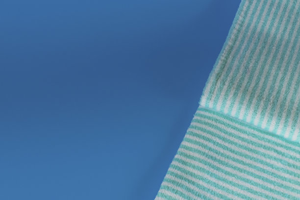 蓝色背景上柔软的毛巾布毛巾。浴巾。个人物品。图片下载