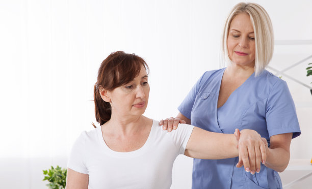 女病人与医生在医院进行咨询。中年妇女在专业诊所康复的照片图片下载