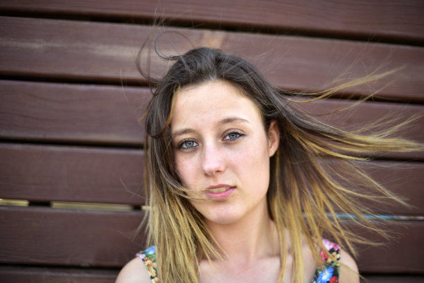 看着木墙旁边的年轻女子图片下载