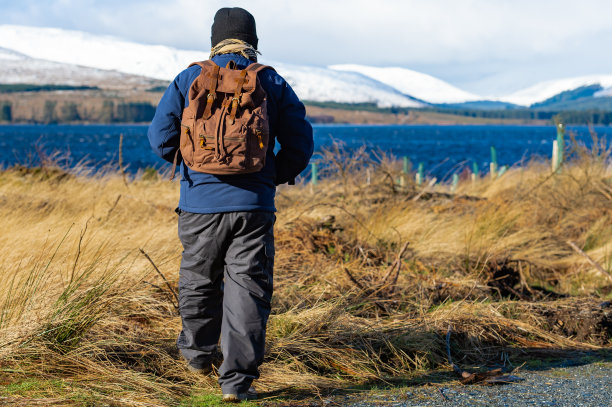 走向苏格兰偏远乡村湖泊的老年男人图片下载