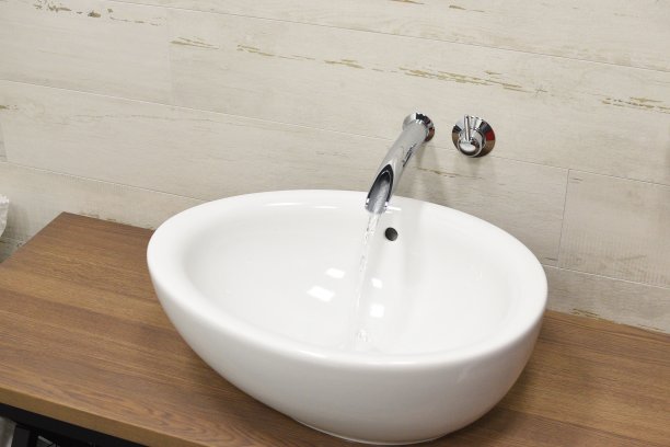 现代浴室内饰设计洗脸盆。白墙背景处的水龙头。棕色的木质台面。豪华水槽白色，主题背景的室内和设计。小sharpne图片下载