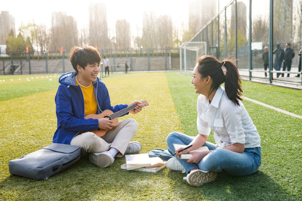 青年大学生在校园里弹奏吉他图片下载
