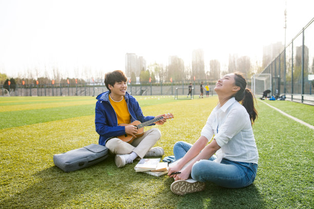 青年大学生在校园里弹奏吉他图片下载