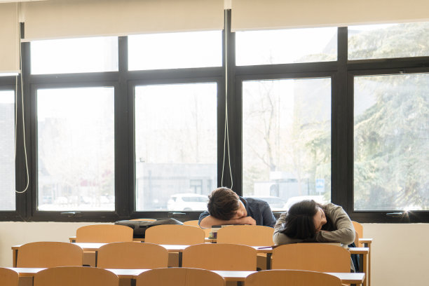 疲劳的大学生在教室里睡觉图片下载