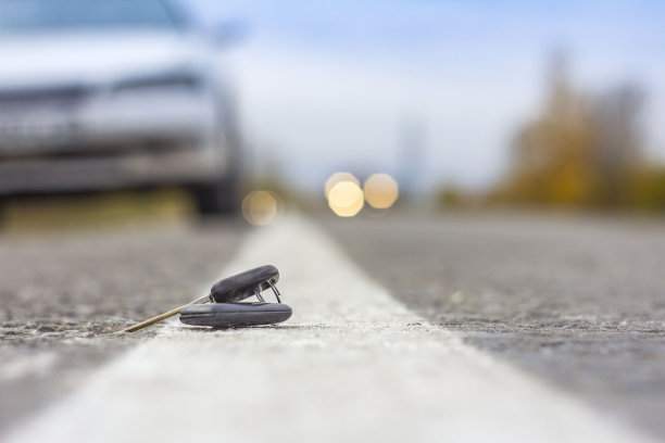 丢失的车钥匙躺在马路上，背景模糊，带有散景效果图片下载