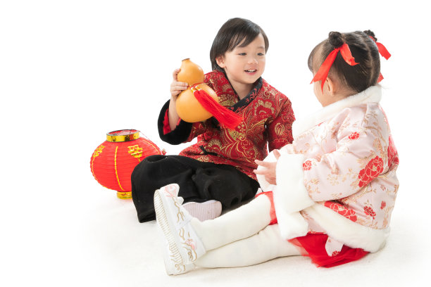 兄妹两人穿新衣服坐在地上庆祝新年图片下载