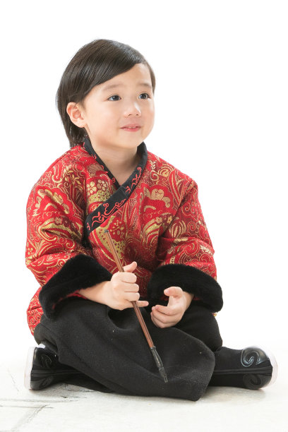 小男孩盘腿坐着拿毛笔写字图片下载