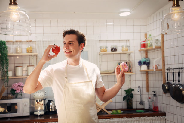 这个年轻人拿着甜椒还是吃甜甜圈犹豫不决。图片下载