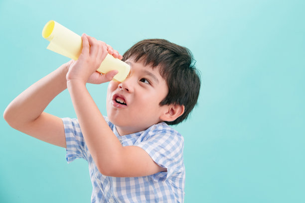 可爱的小男孩用纸质望远镜图片下载