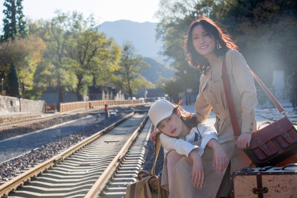 青年闺蜜坐在火车站站台旁图片下载